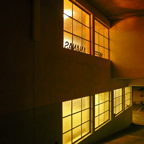 Tanz- und Eventlocation mit warm beleuchteten Fensterflächen auf zwei Ebenen.