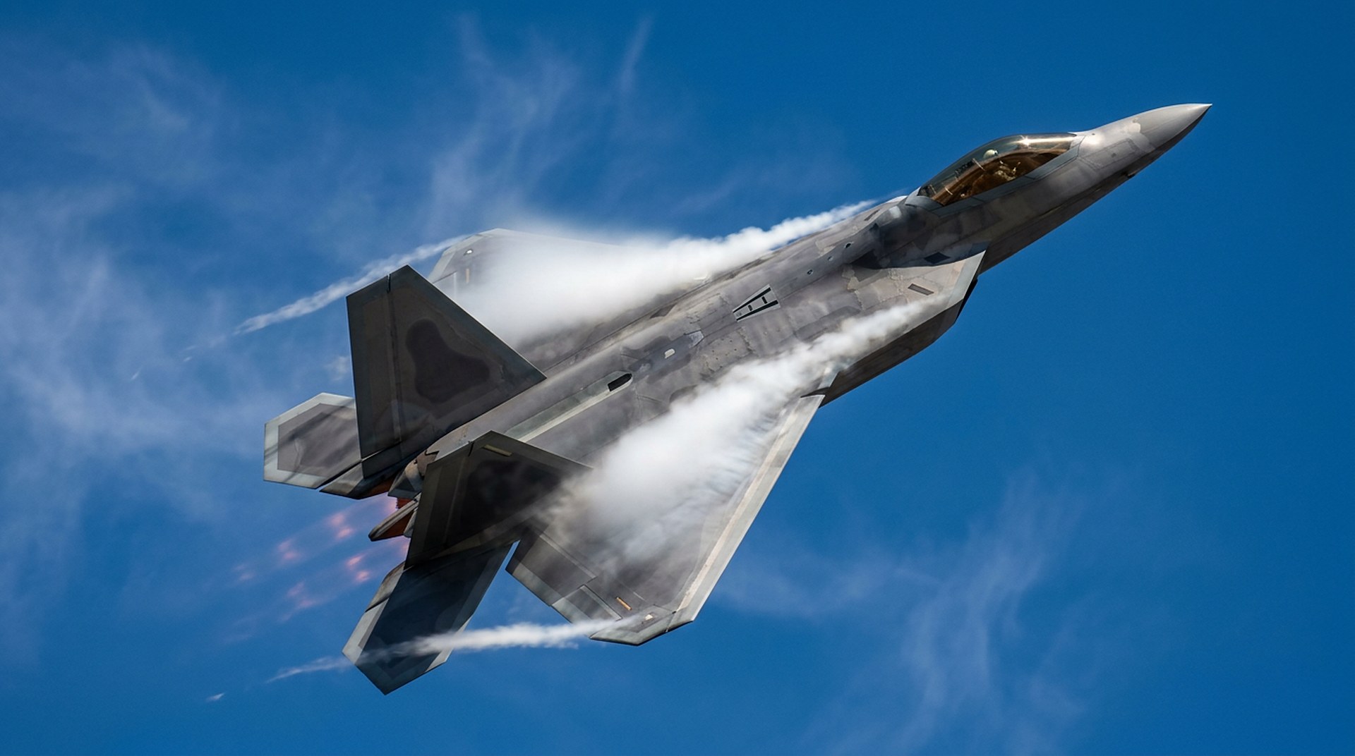 F-22 Raptor in a vertical climb trailing vapour