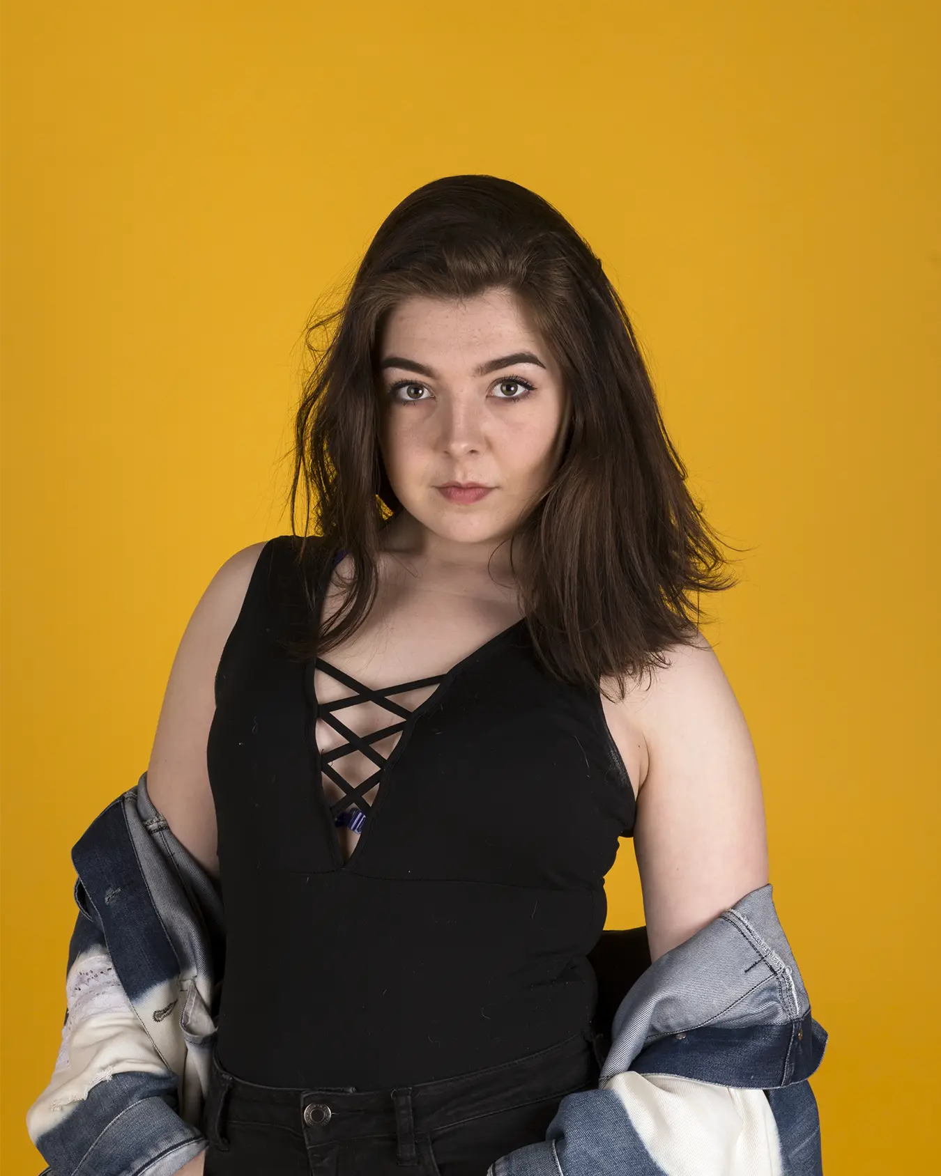 Studio photo of Kathleen H. on a yellow backdrop.