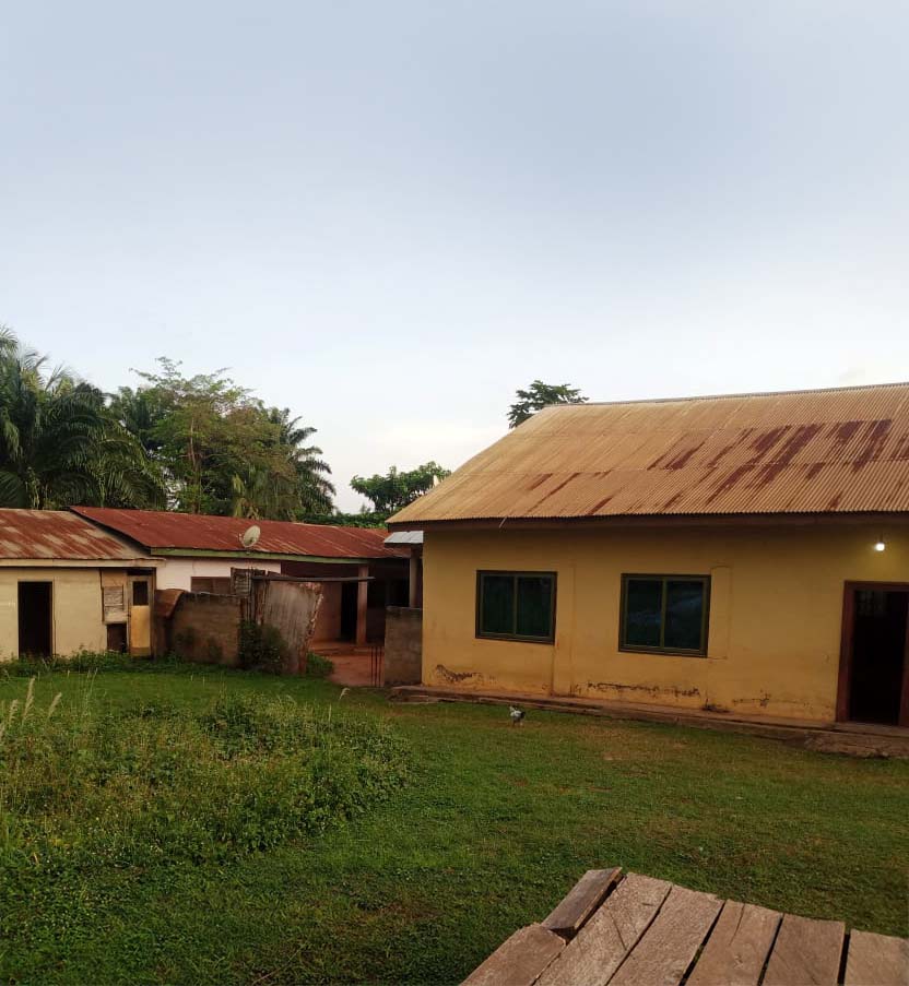 A photo of a new location that will become a D1:8 center. The photo contains 2 cement buildings in need of some work.