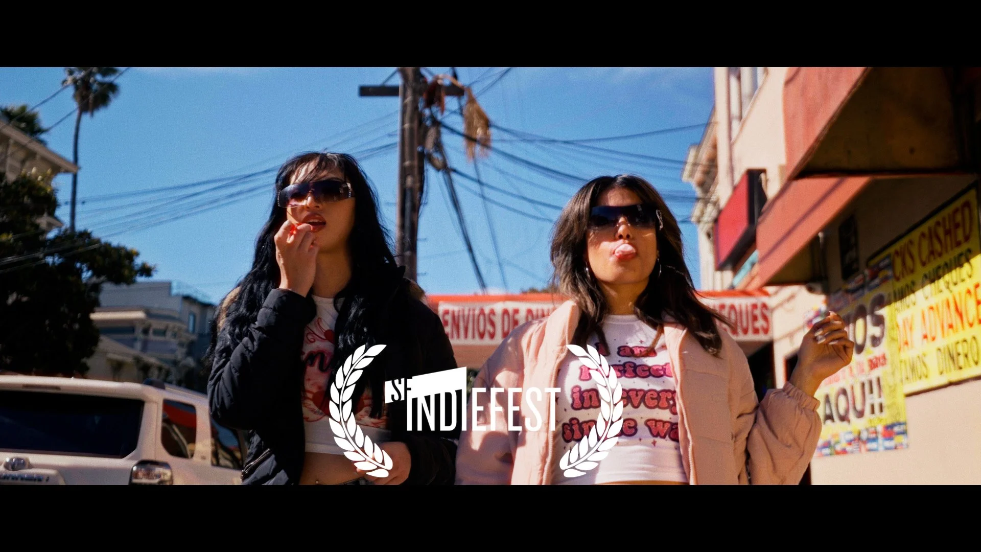 Deville film still of two people on a neighborhood sidewalk with an IndieFest laurel.
