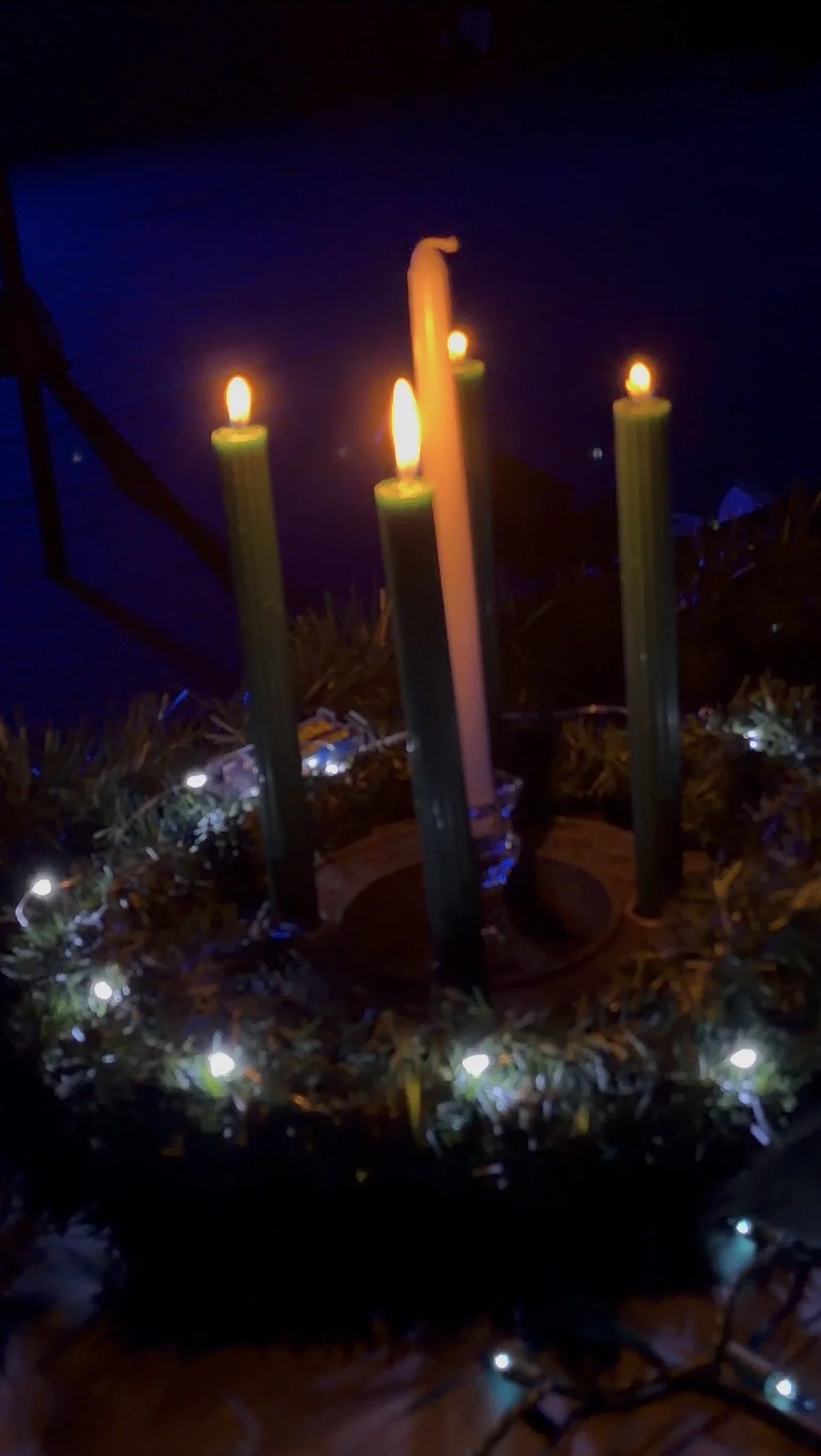 Lit candles arranged in an Advent wreath.