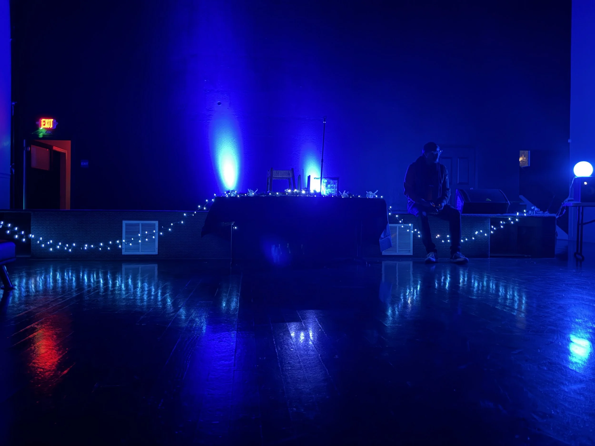 A blue-lit room decorated with strings of lights.