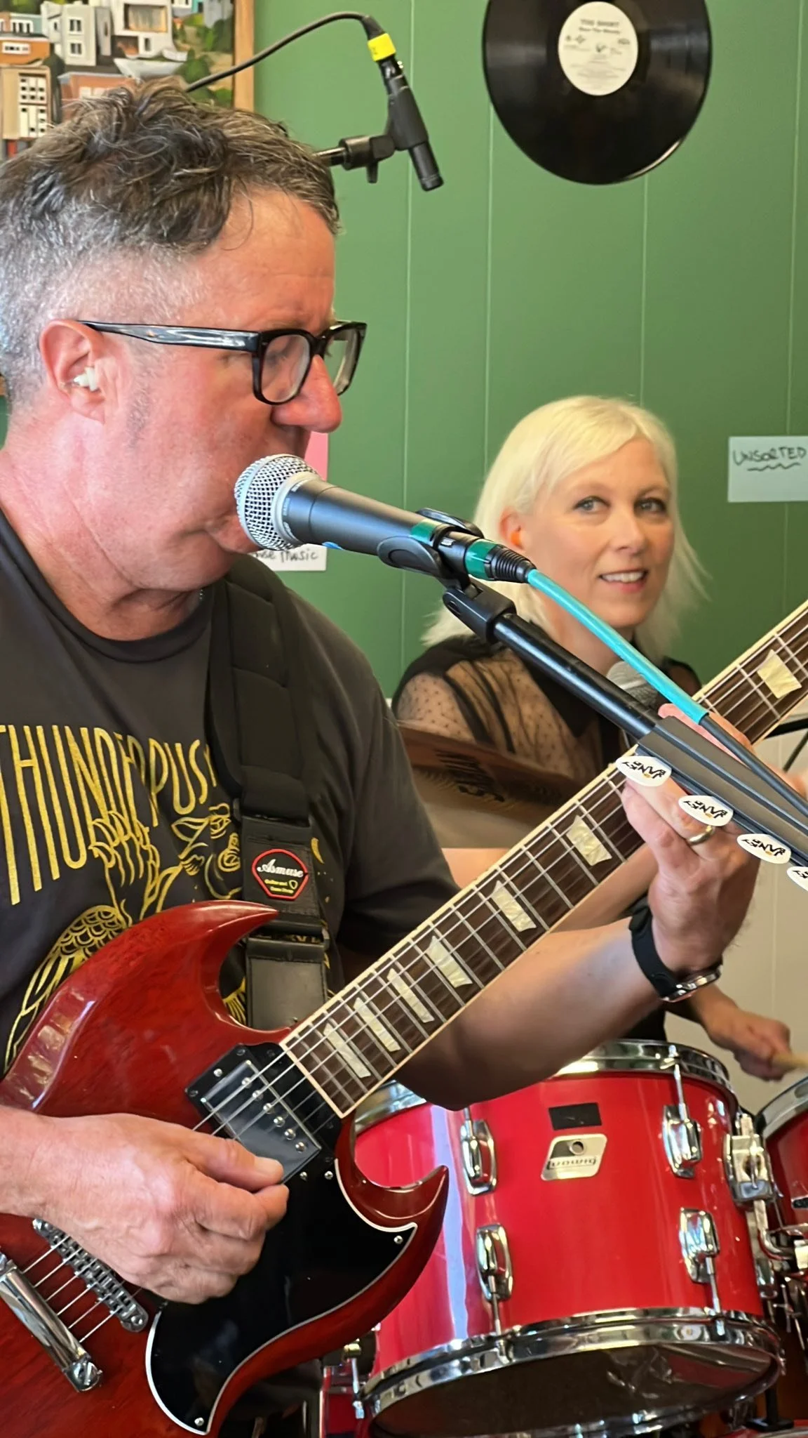 Close view of a guitarist singing into a microphone.