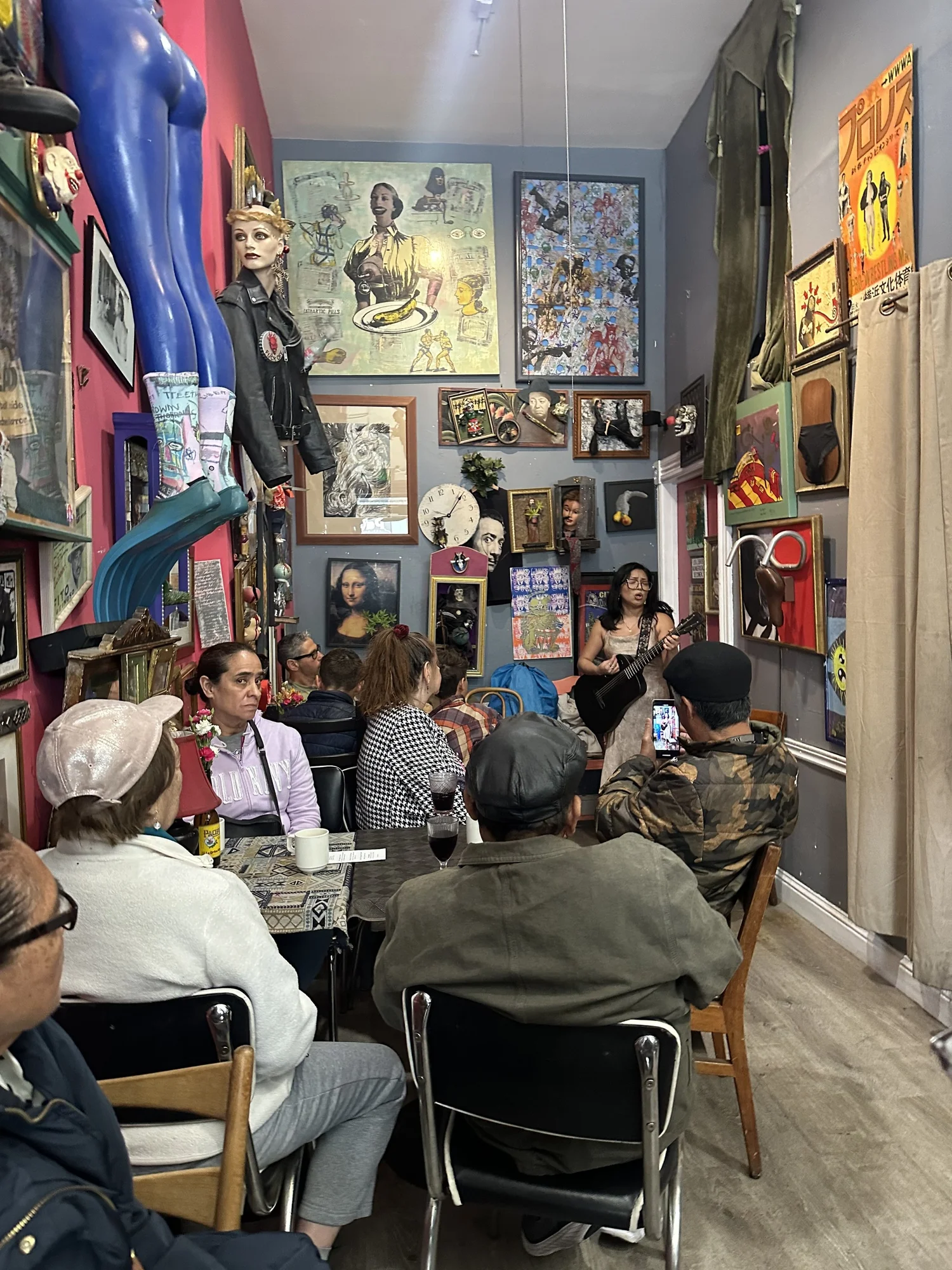 A performance gathering surrounded by artwork and sculpture.
