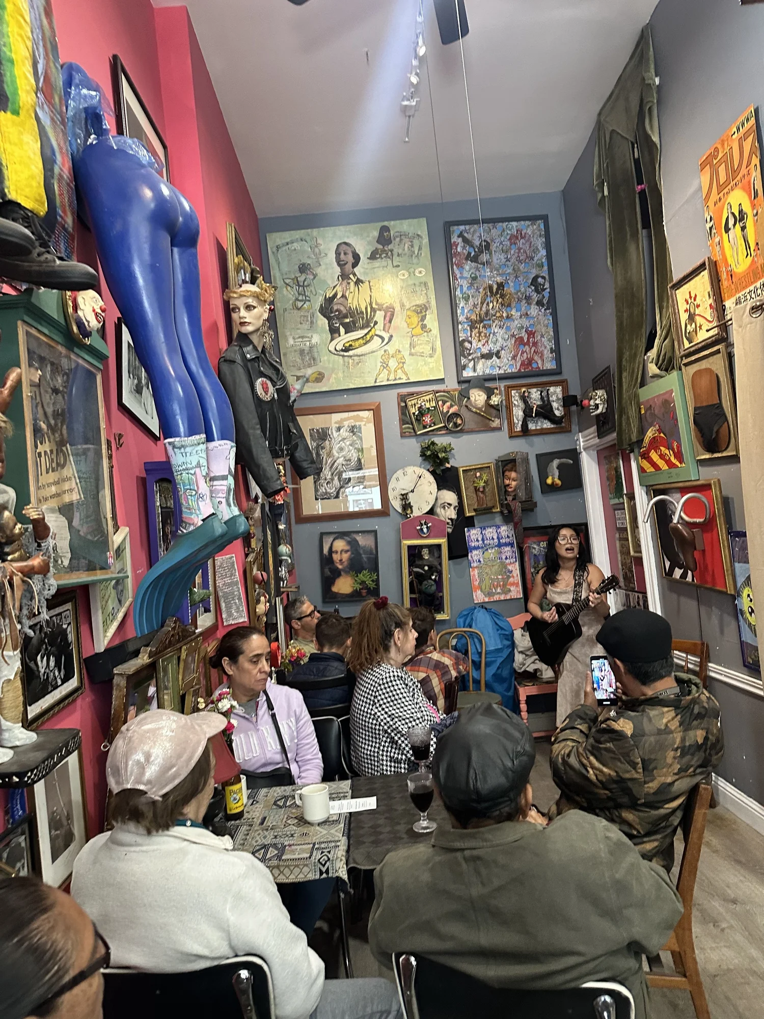 Audience members listen inside the art-filled venue.
