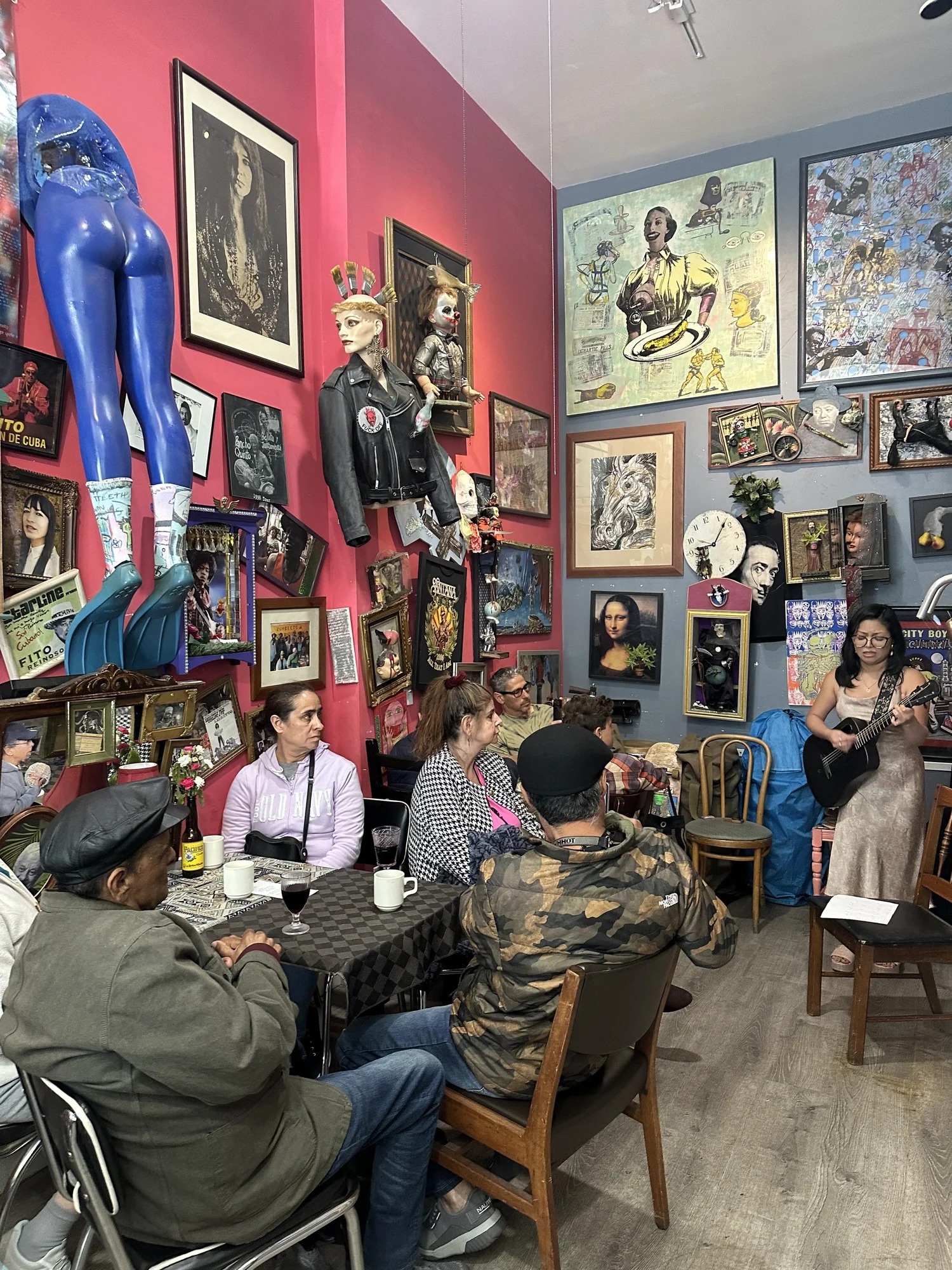 Guests sit together in a room filled with framed paintings.