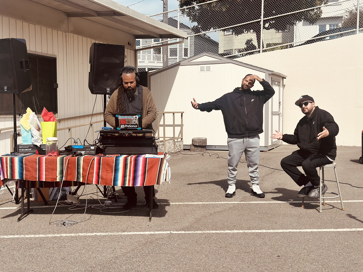 Performers and a DJ entertain a schoolyard audience.