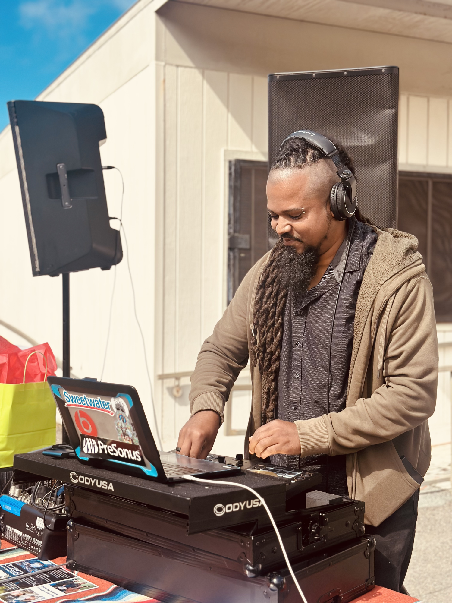 A DJ operates a mixer and laptop.