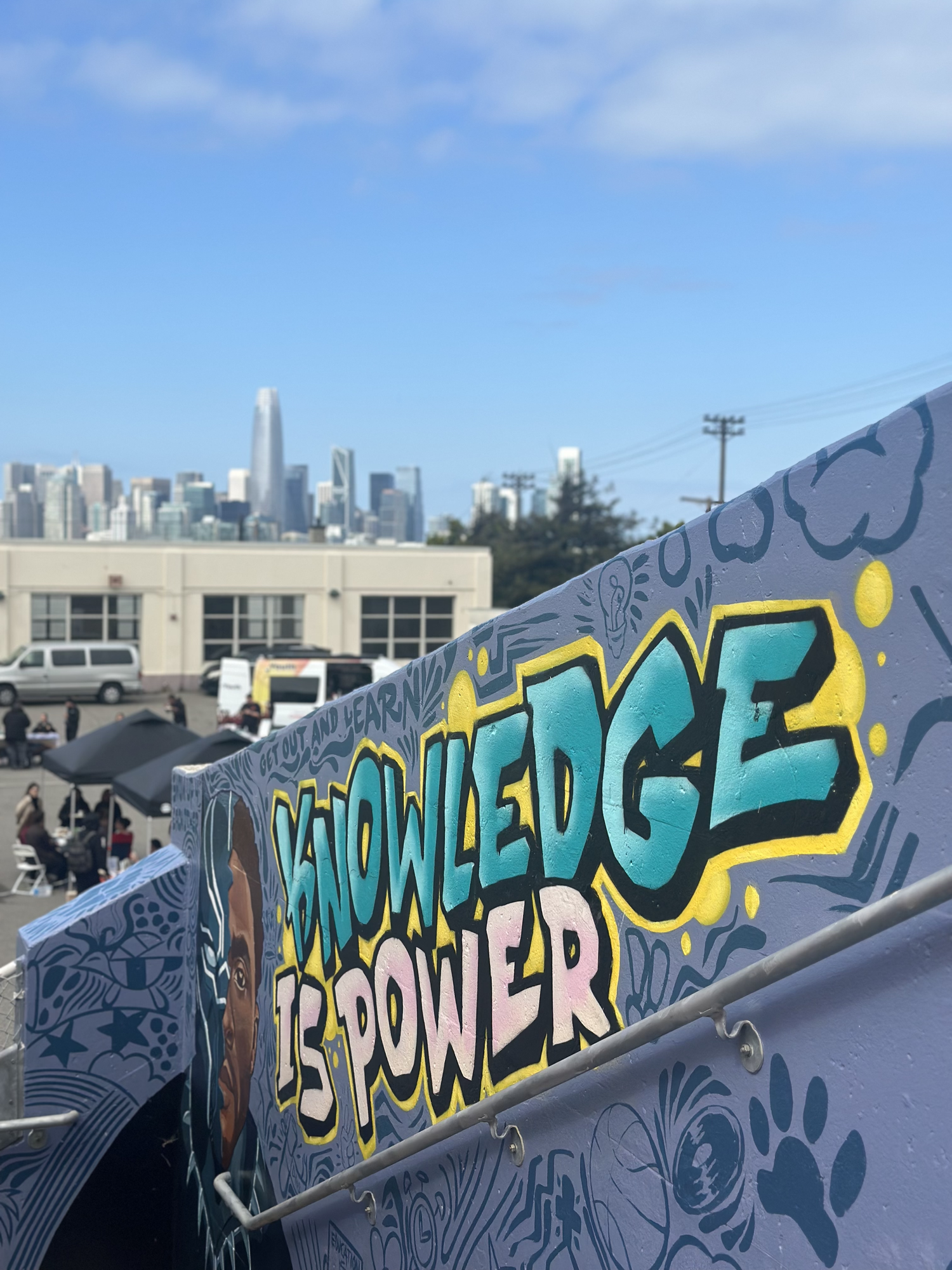 A mural reading Knowledge is Power overlooks the city.