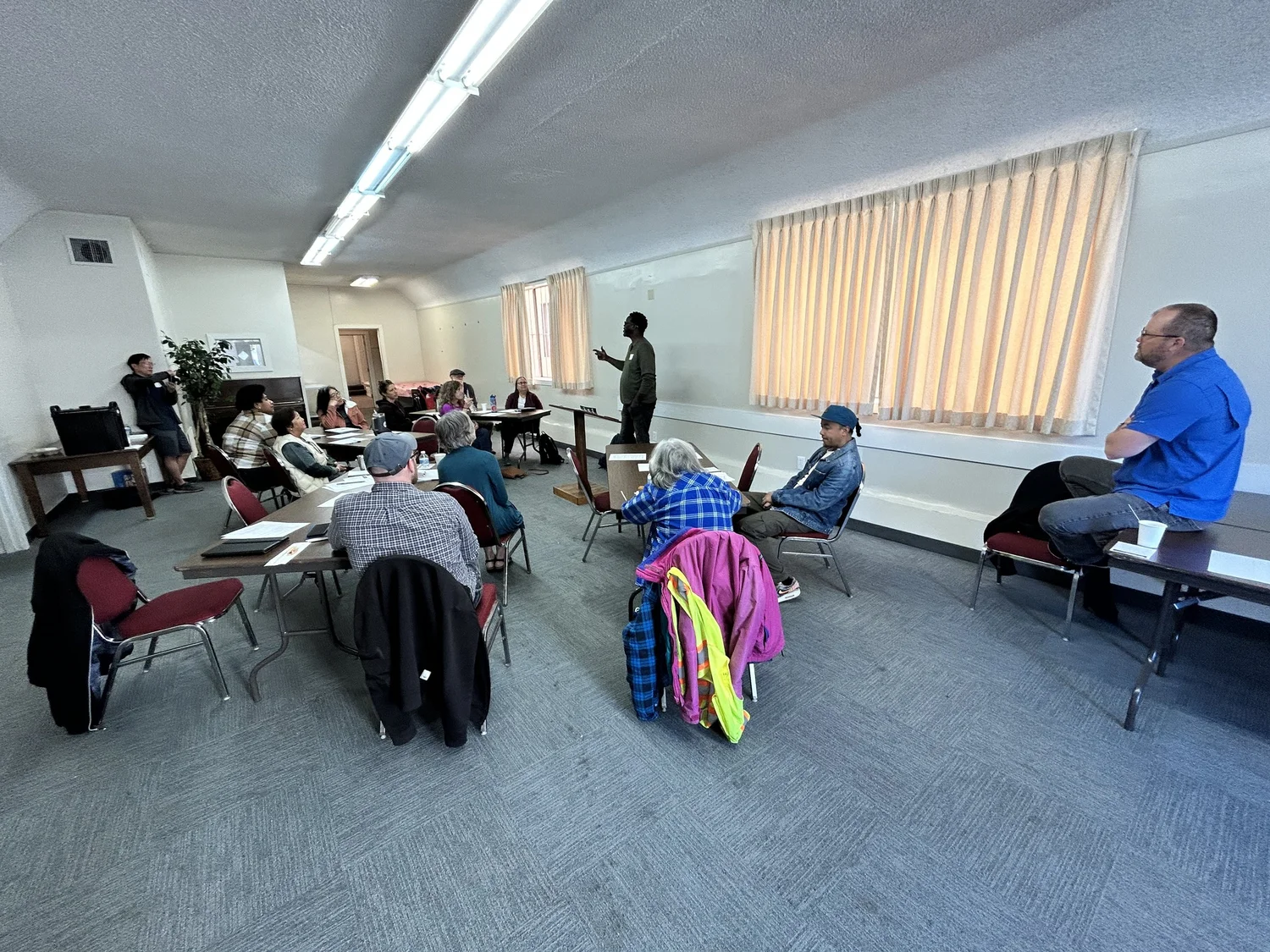 Participants listen to a discussion in a meeting room.
