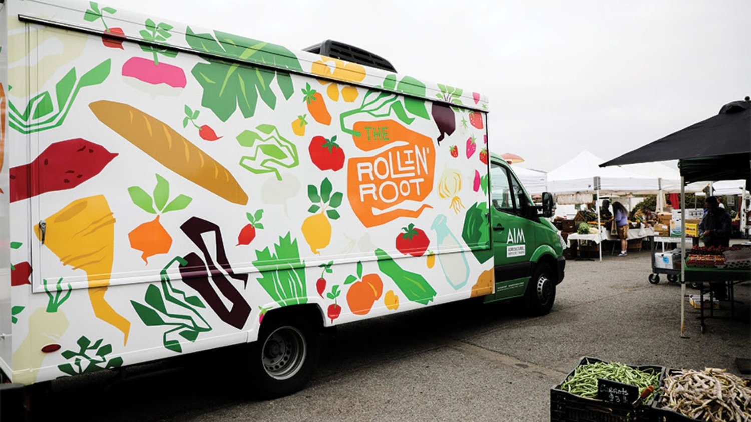 Colorfully illustrated Rollin' Root food truck at an outdoor market.