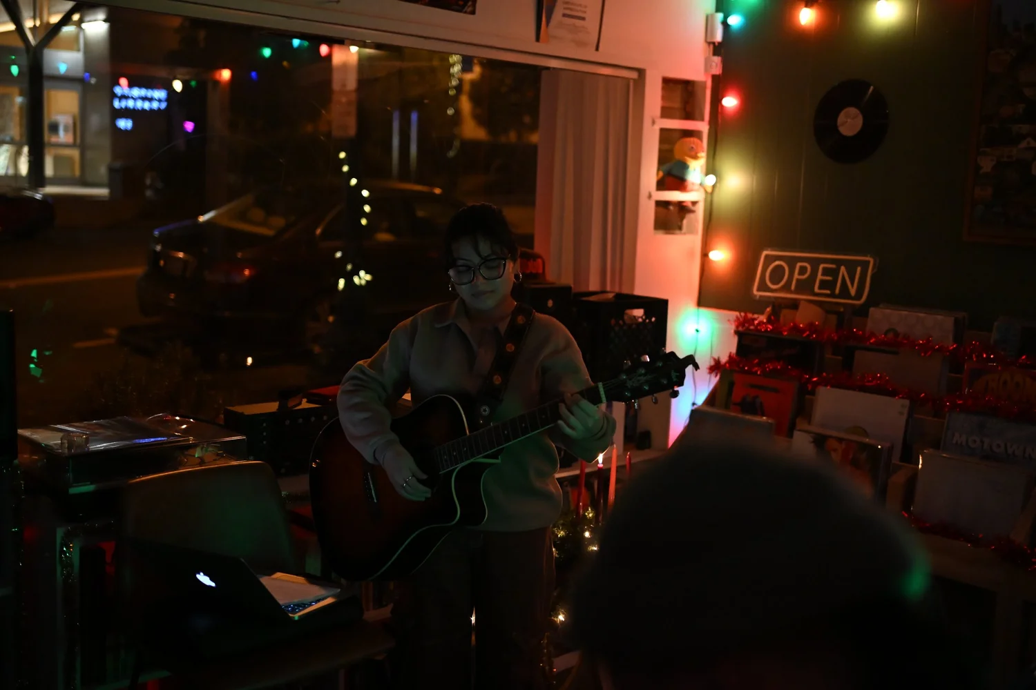 A guitarist performs in a dimly lit room.