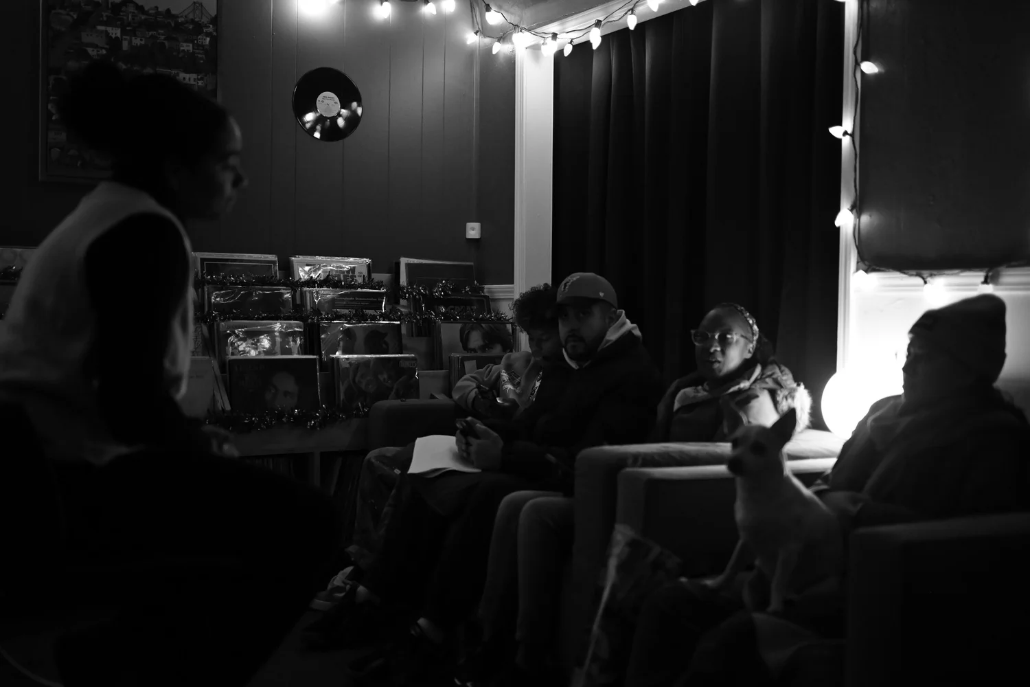 The group listens to a speaker in the record shop.