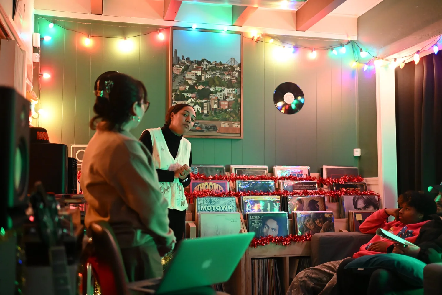 Participants lead a gathering beside shelves of records.