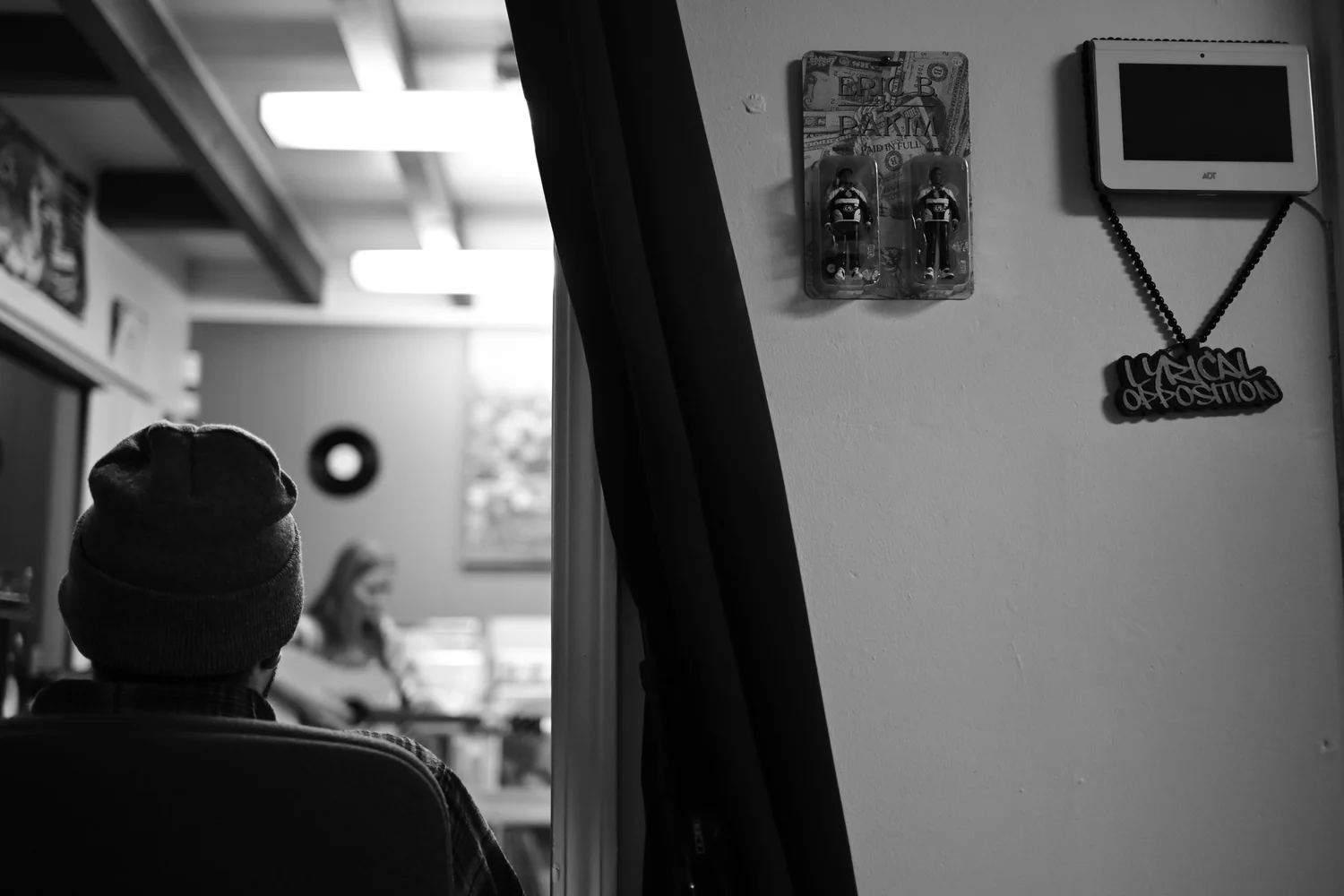 Black-and-white view past an attendee toward the performance room.