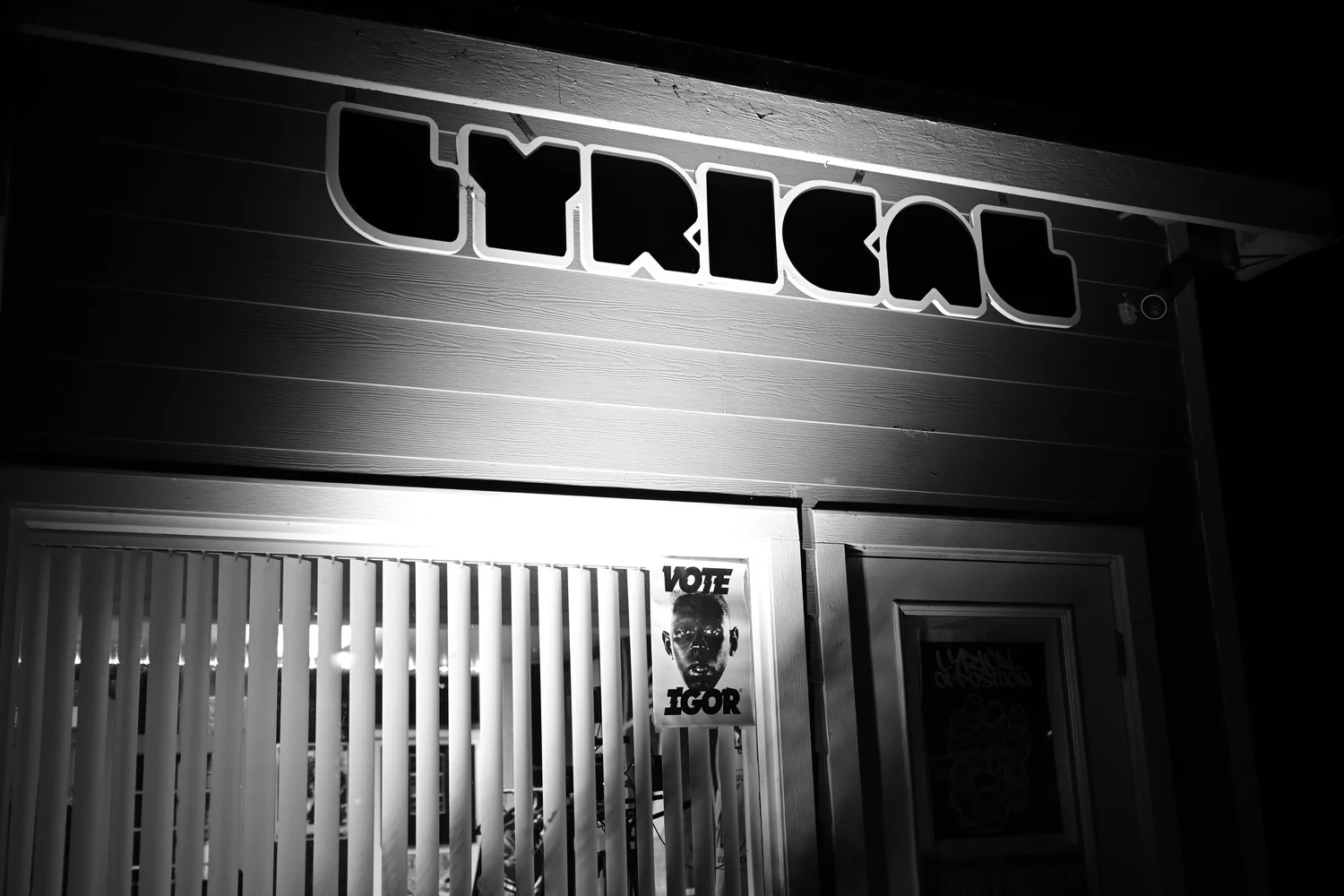 Black-and-white night view of the Lyrical storefront sign.