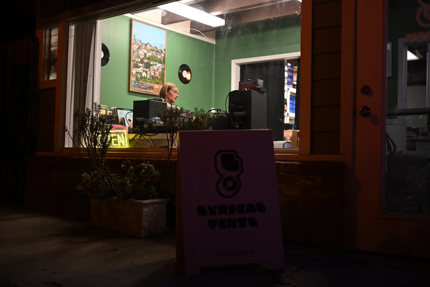 Night view through the venue window toward a performer.