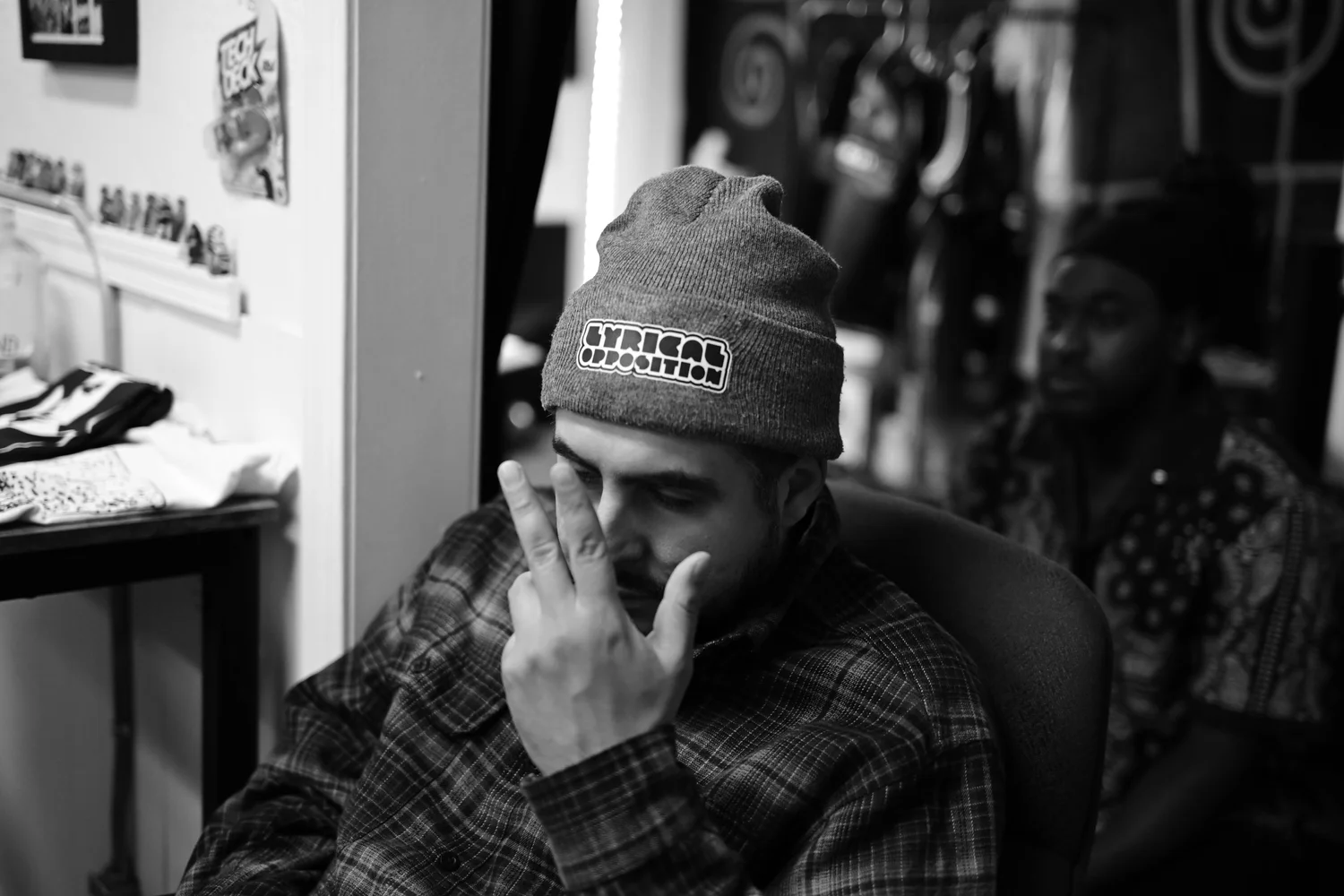 Black-and-white portrait of a seated attendee wearing a beanie.