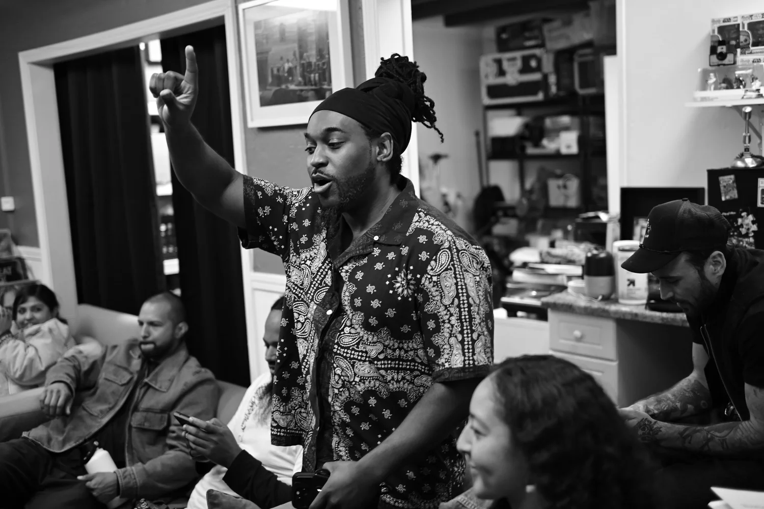 Black-and-white photo of a participant raising an arm among the audience.