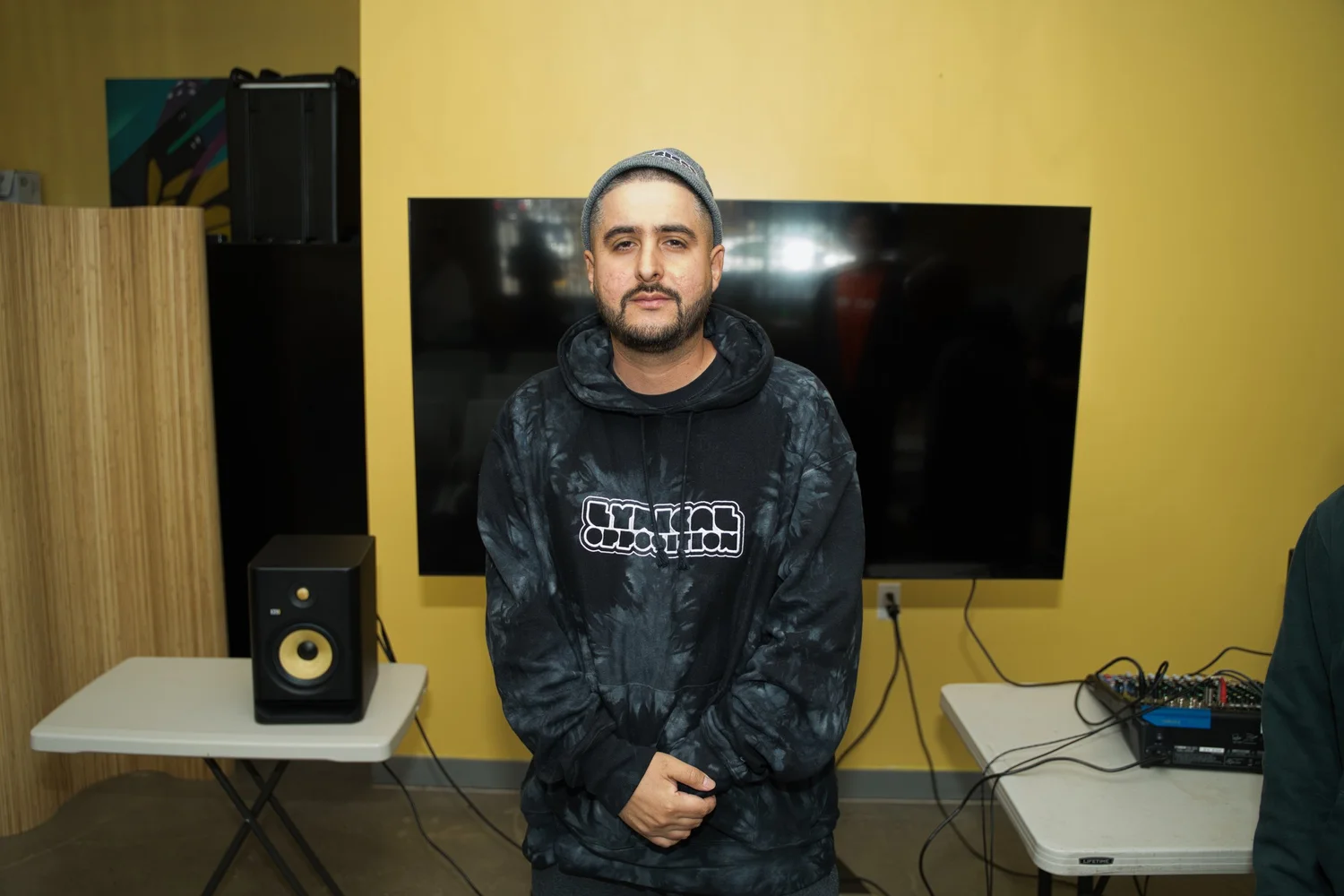 Participant in a beanie posing in front of a screen.