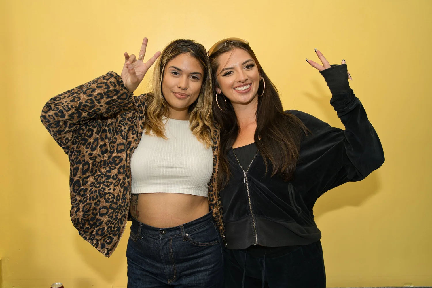 Two smiling attendees posing with peace signs.