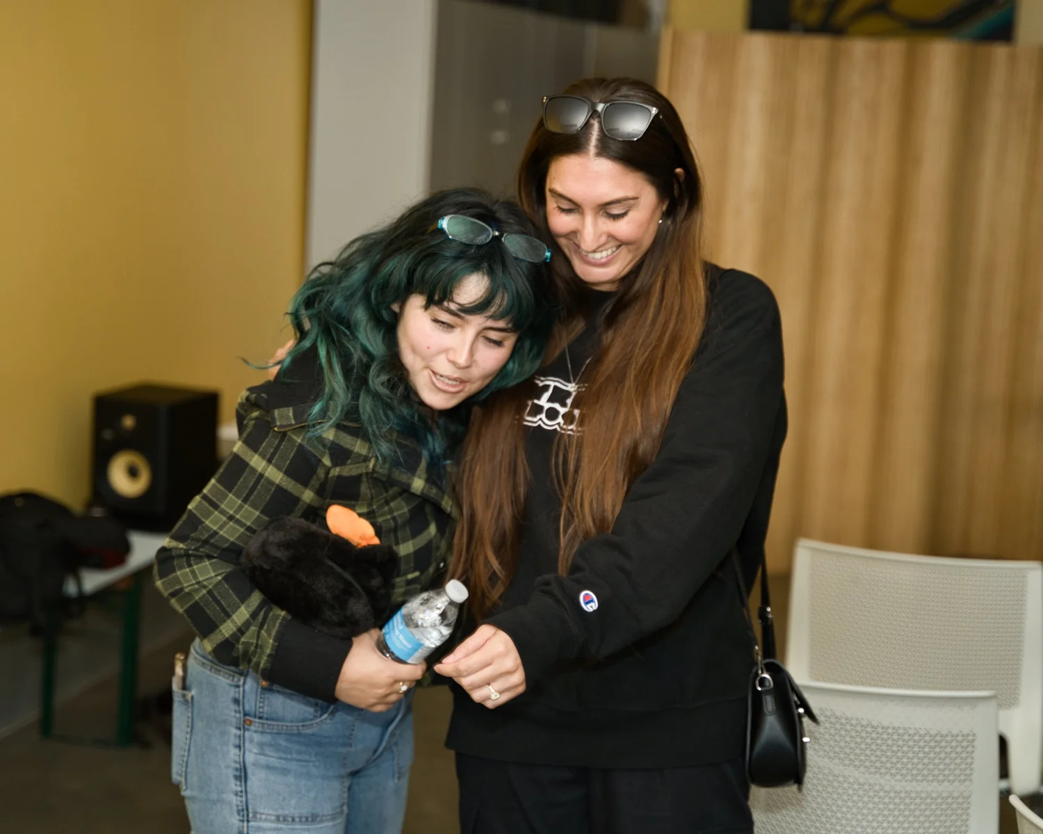 Two smiling attendees leaning together.