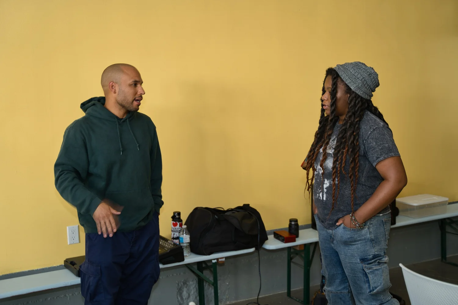 Two participants talking beside a row of chairs.