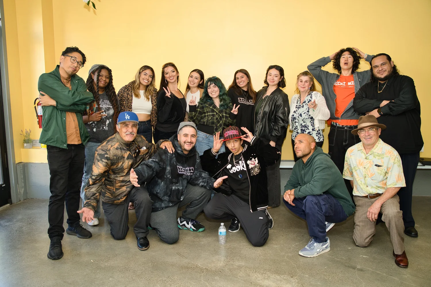 Group portrait against a yellow wall at 99 Leland.