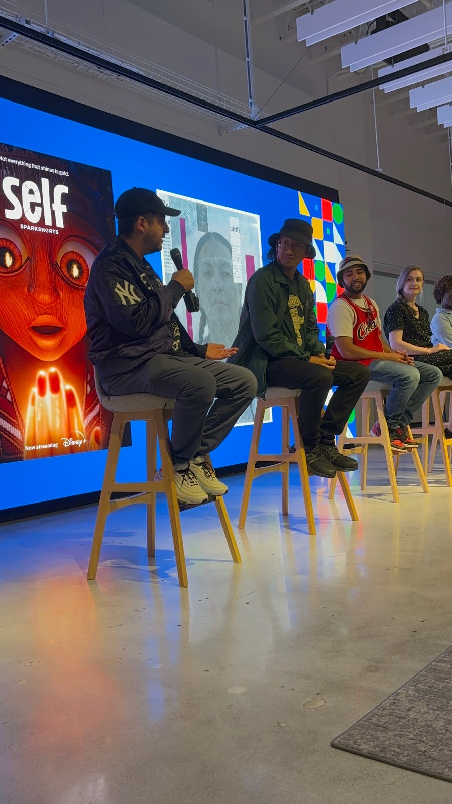 Panelists speak beside a presentation screen.