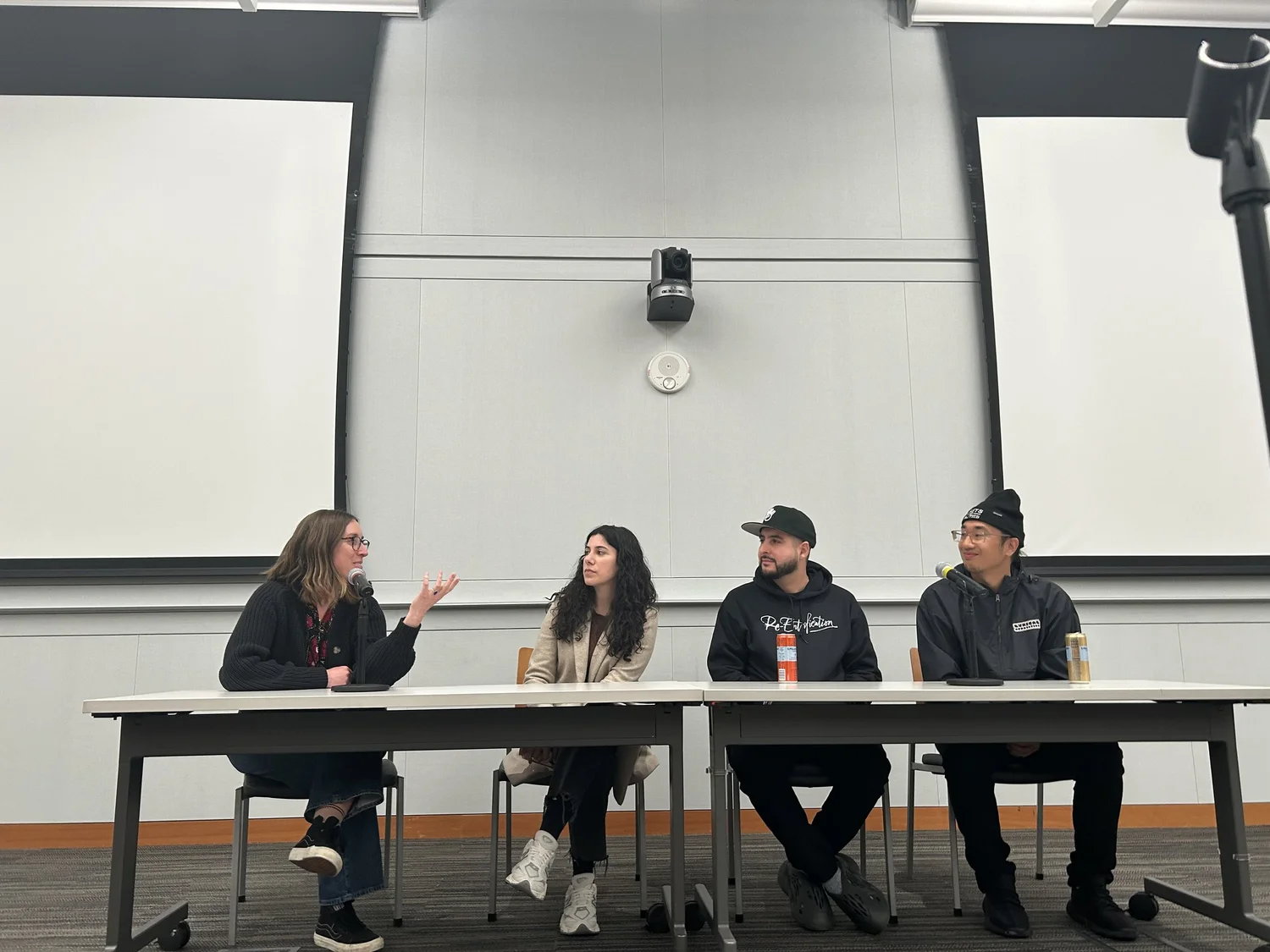Four panelists discuss the documentary from behind a table.