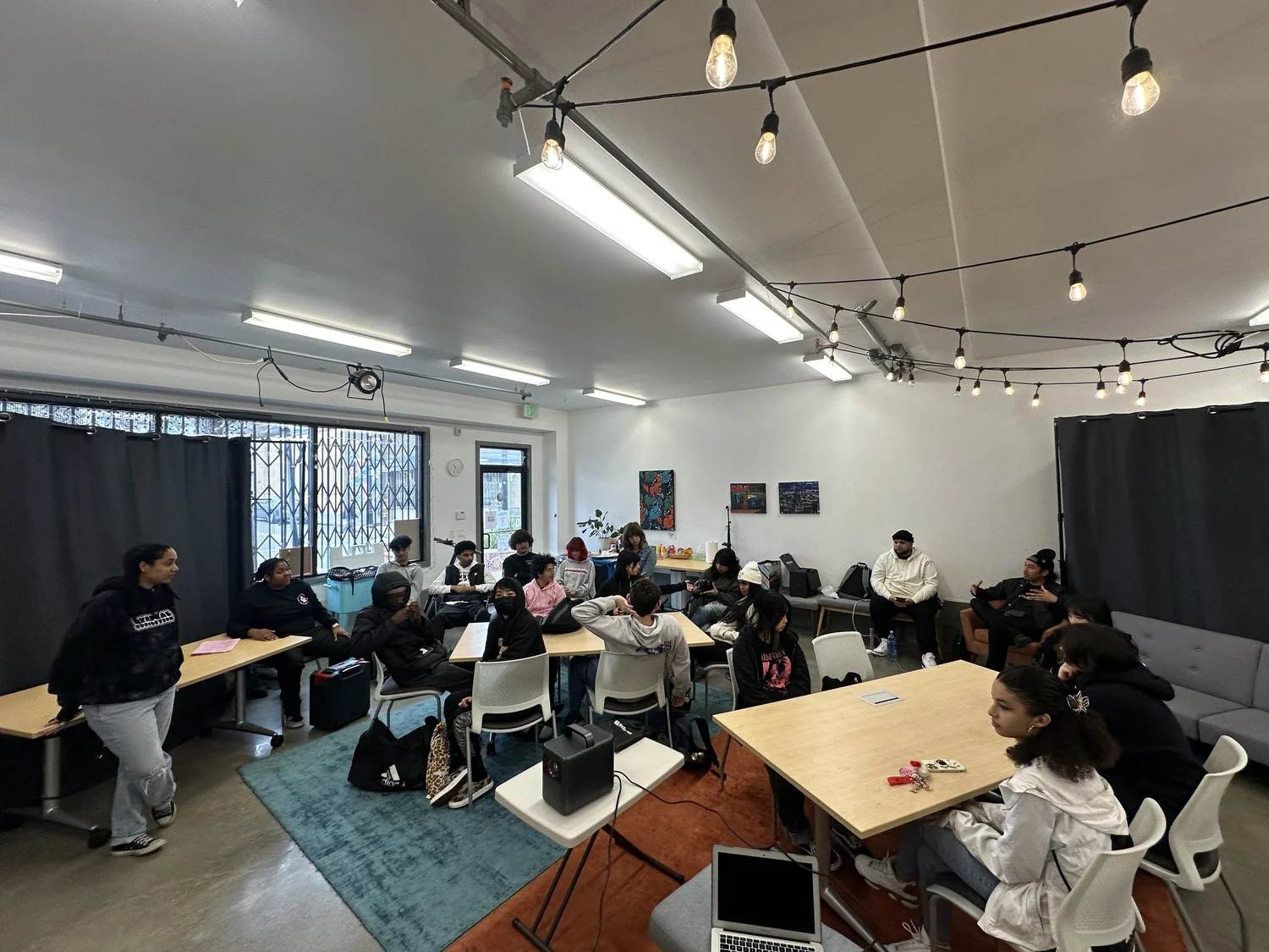 A speaker addresses students seated in the gallery.