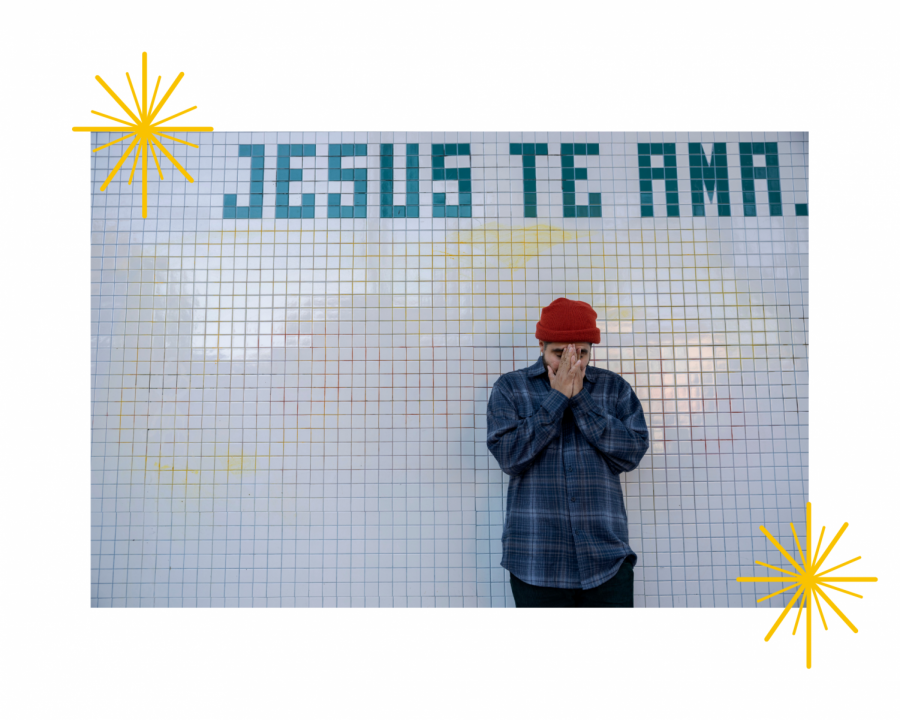 An artist stands beneath the words Jesus Te Ama.