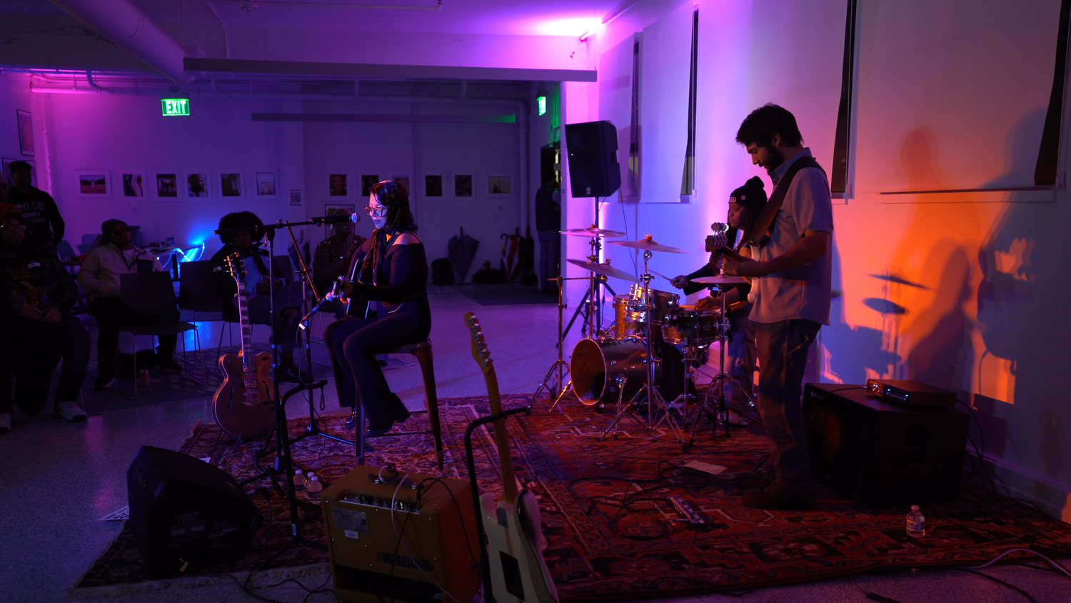 A band performs under purple and orange lighting.