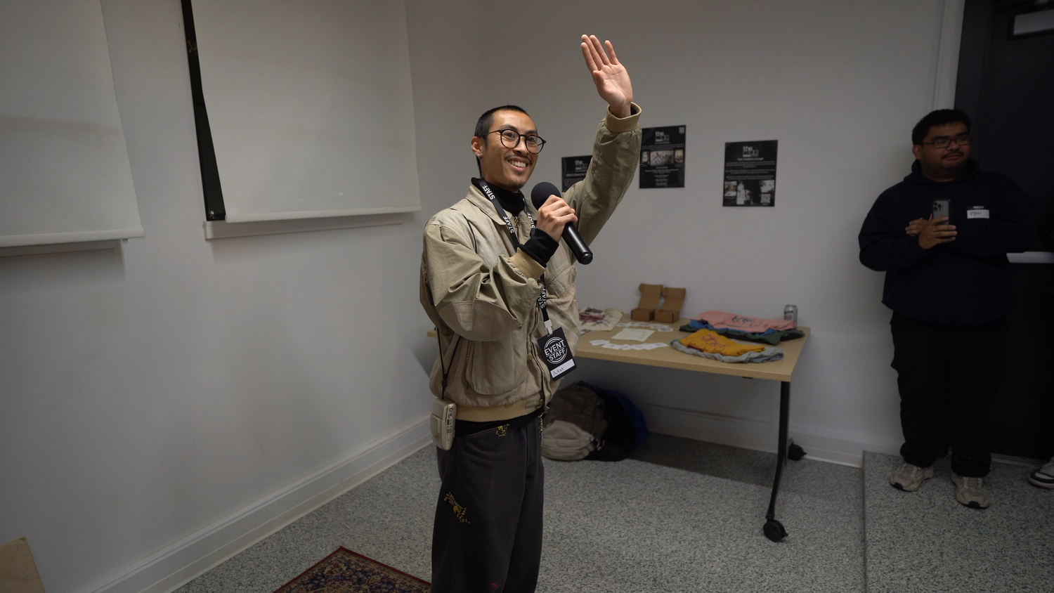 A presenter raises a hand while addressing visitors.
