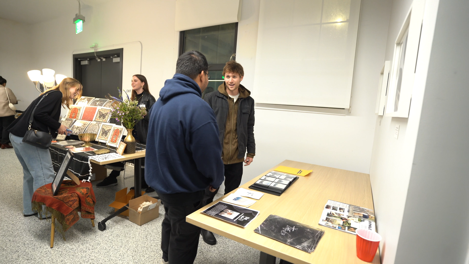 Visitors converse beside exhibition materials.