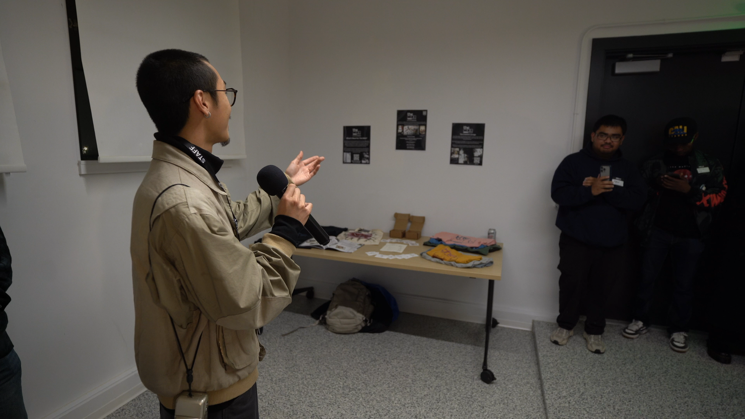 A presenter gestures toward a photographic installation.