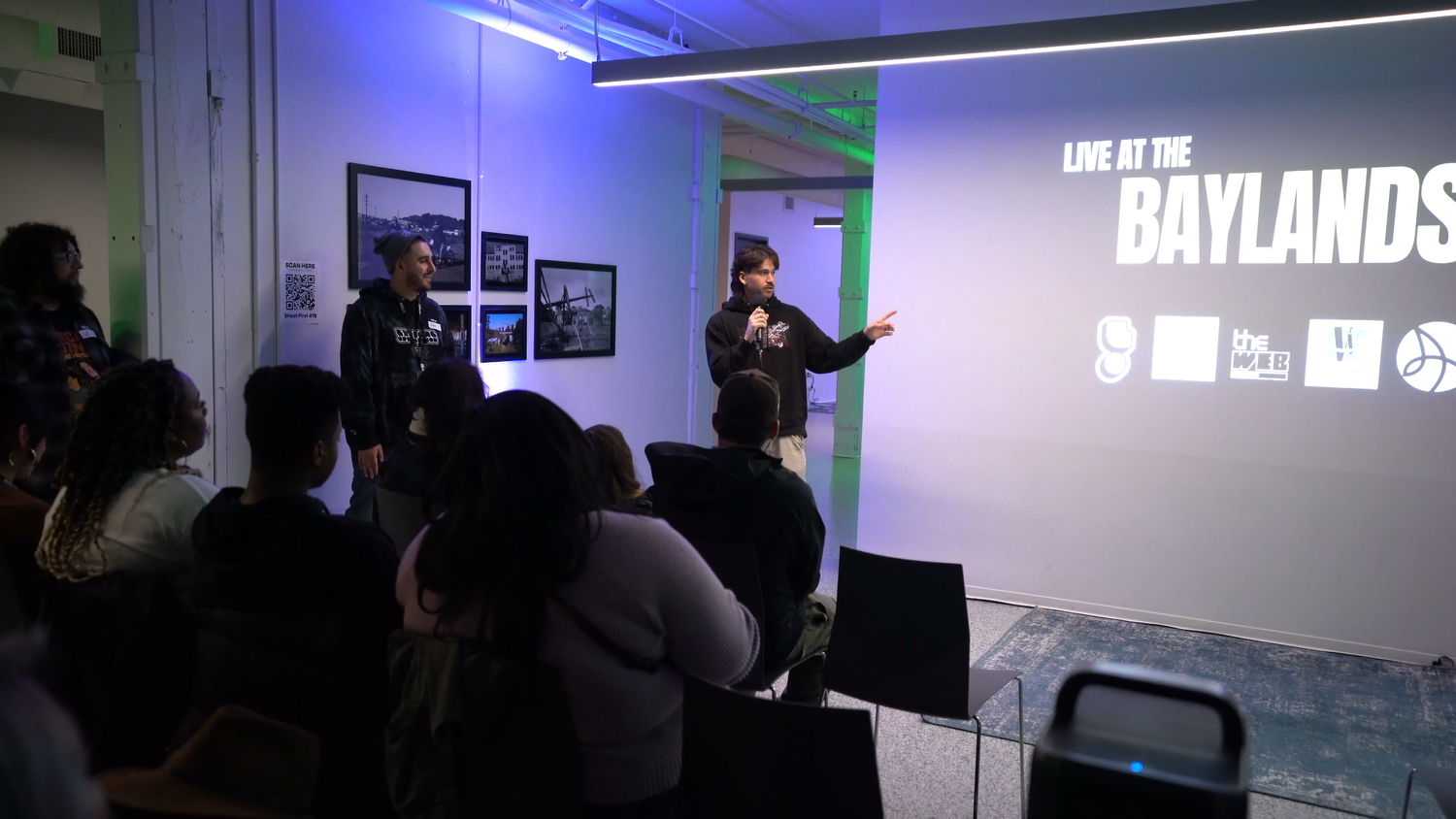 A speaker gestures in front of the Live at the Baylands title.