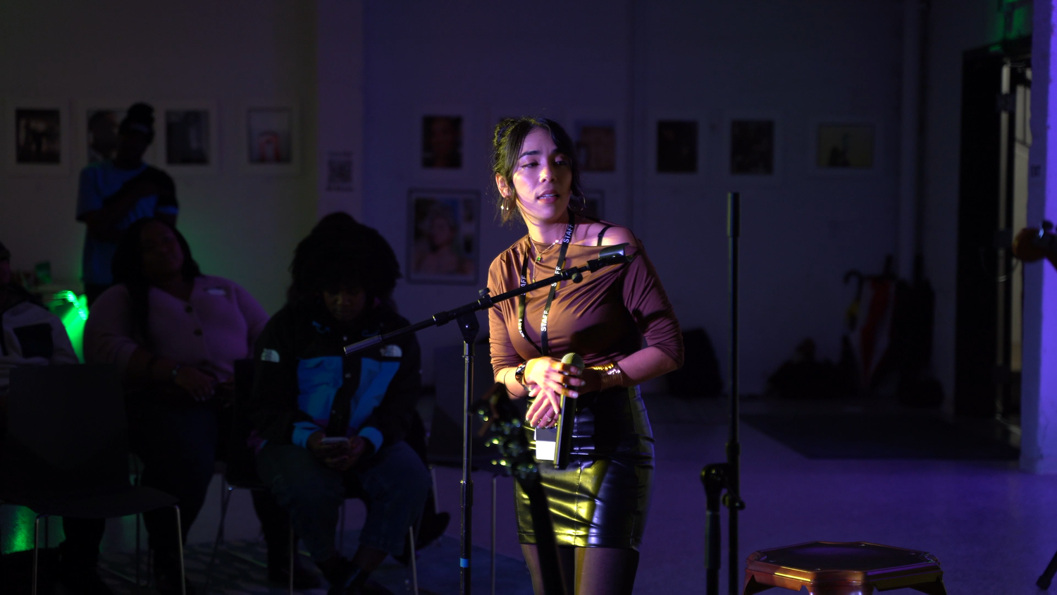 A singer addresses the audience under colored lights.