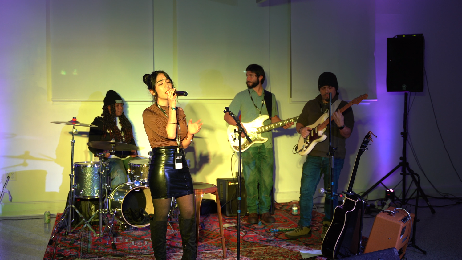 The band performs under warm yellow stage lighting.