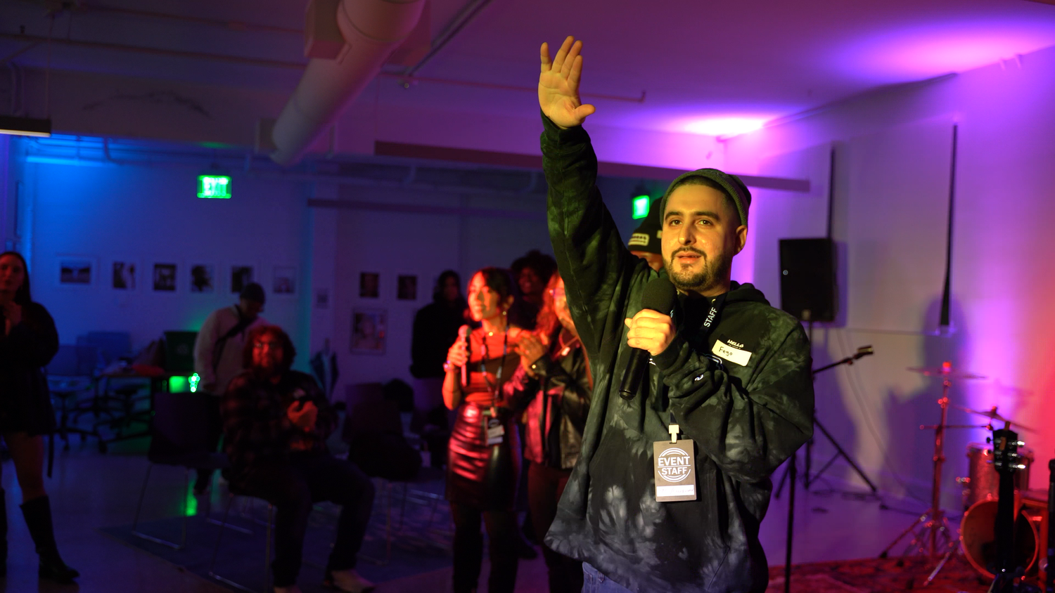 A speaker raises one hand toward the audience.