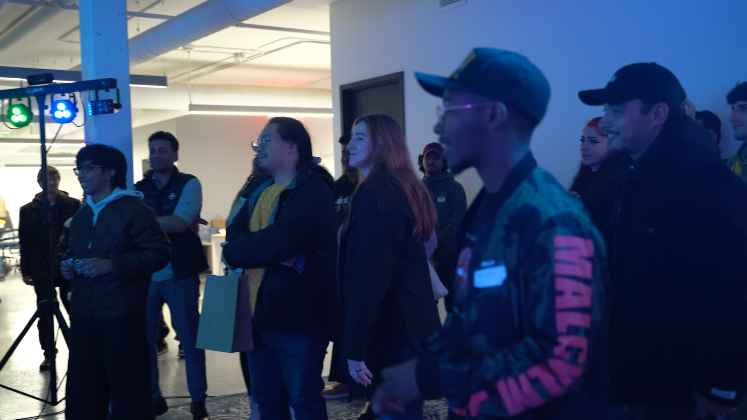 Guests watch the performance in the blue-lit gallery.