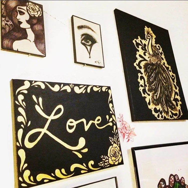 Framed drawings and paintings, including the word Love.