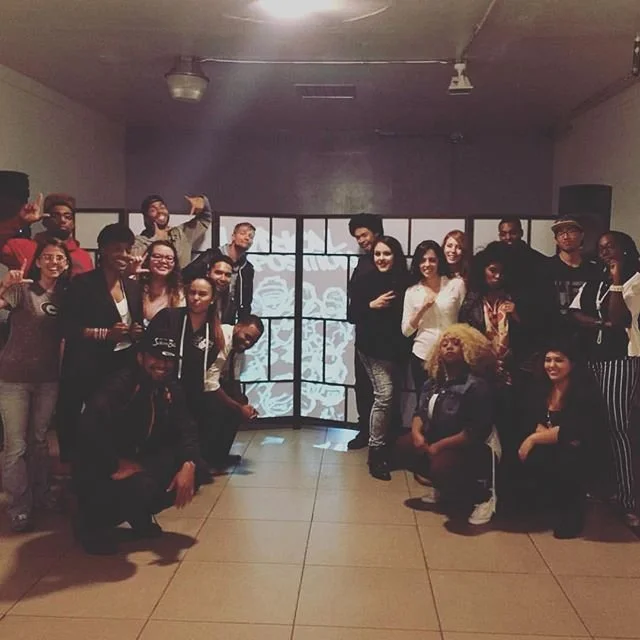 Performers and guests pose together at the open mic.