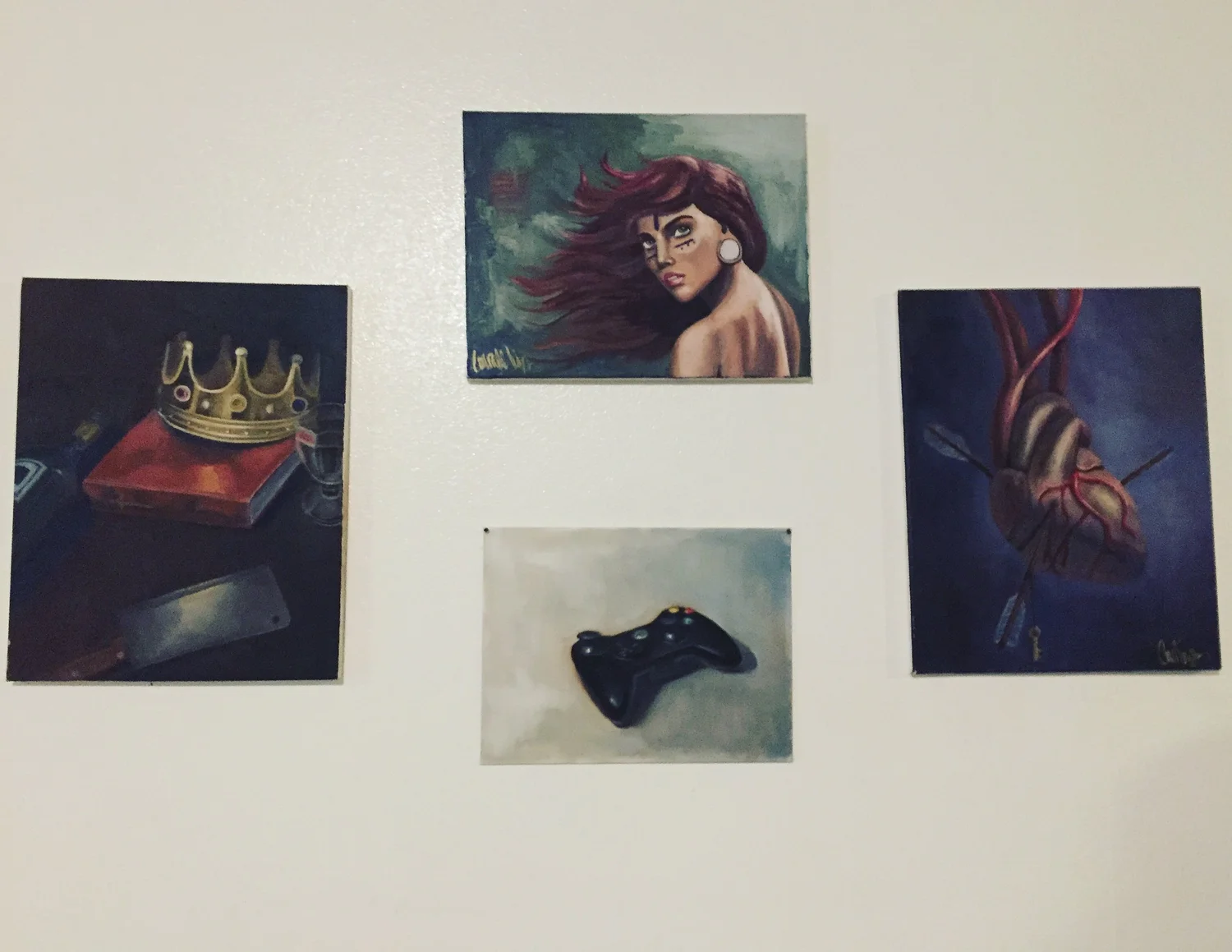 Portraits and paintings arranged on a gallery wall.