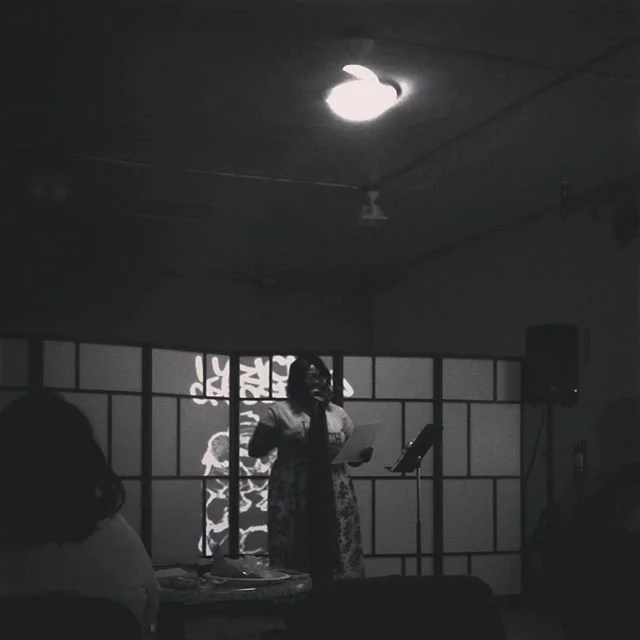 Black-and-white portrait of a performer onstage.
