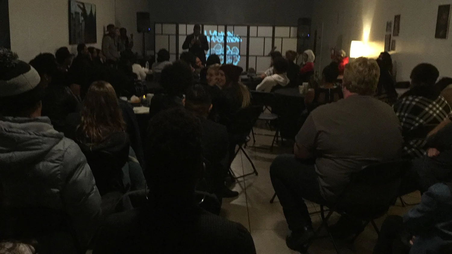 Guests listen to the performer from rows of chairs.