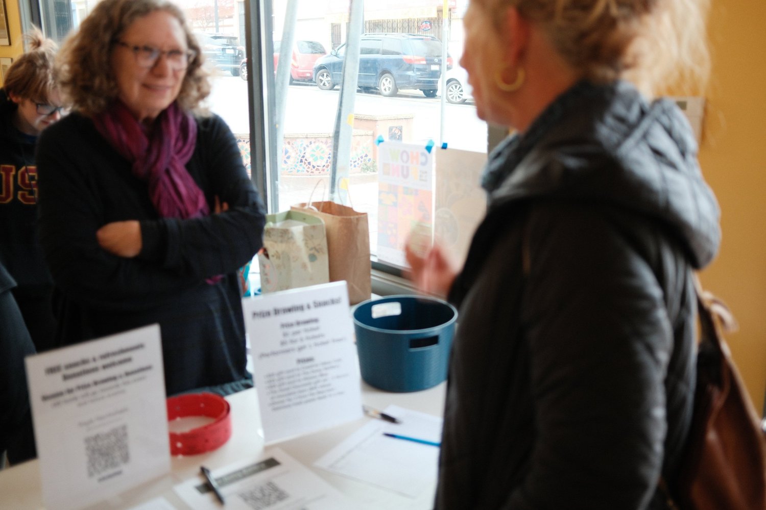 Two attendees talking at the welcome table.
