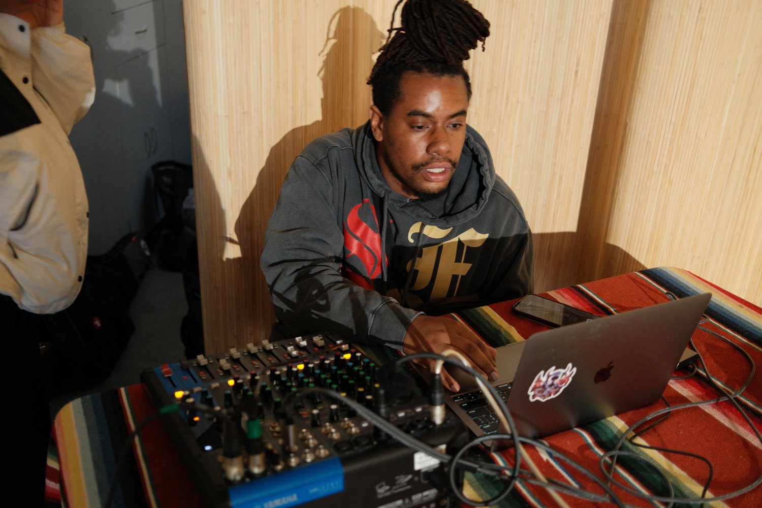 DJ working at a laptop and audio mixer.