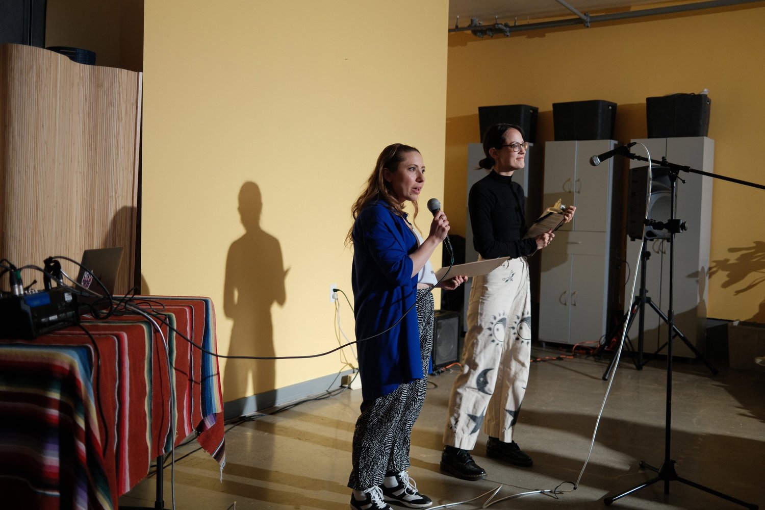 Two participants sharing a microphone at the front of the room.